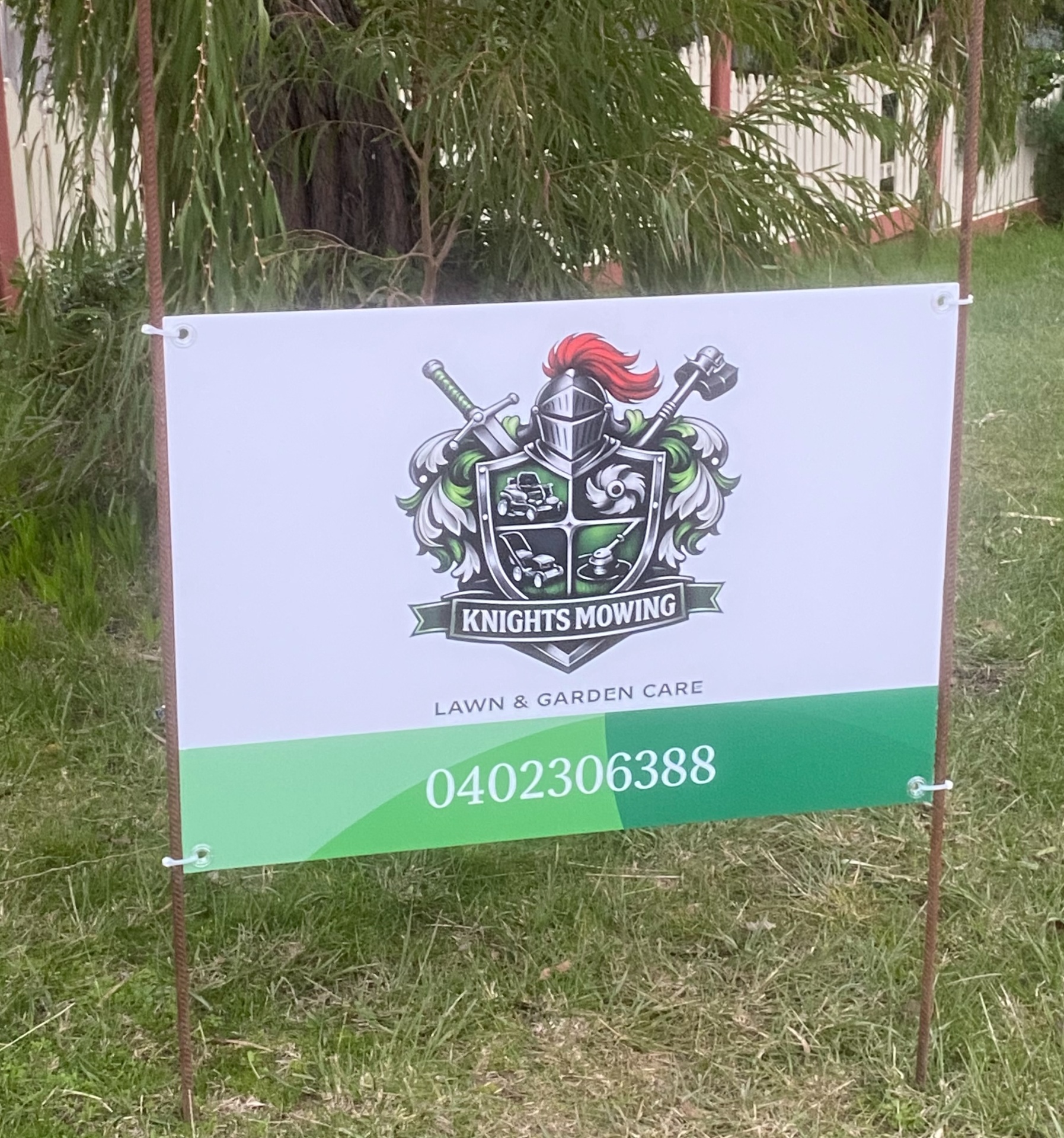 Knights Mowing yard sign staked on a freshly mown Pakenham lawn, showing the crest logo and phone number 0402 306 388
